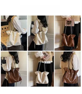 Detailed view of cream and brown leather drawstring tote bags with chain straps