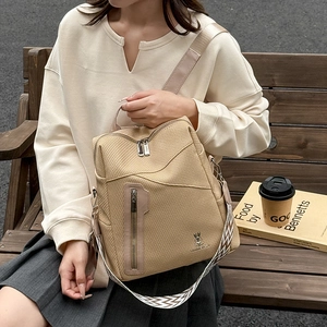 Detail of beige woven texture backpack with silver zippers and stylish patterned strap