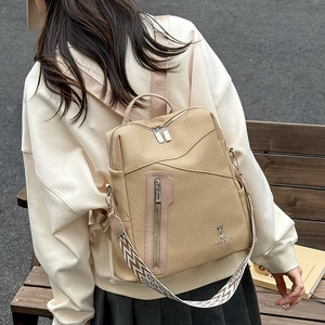 Detail of khaki woven PU leather backpack with decorative geometric pattern strap