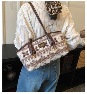 Faux shearling tote bag with brown leather straps and metal logo shown on model back