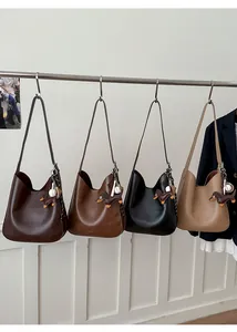 Detail view of four colorful hobo bags with dachshund charms and braided stitching