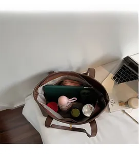 Interior view of brown tote bag showing large capacity with tablet and daily essentials