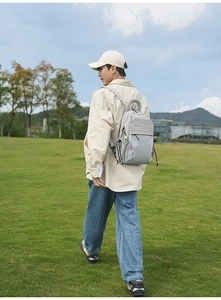 Vue arrière d'un sac à dos en nylon gris clair déperlant porté par un modèle masculin