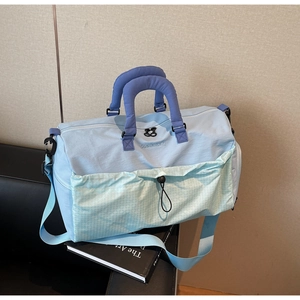 Close-up of lightweight travel bag with thick quilted handles and mesh front pocket