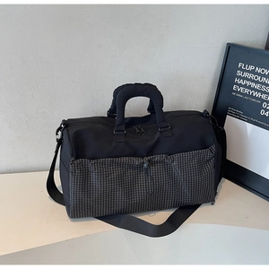 Detail of the large travel duffel bag showing a black and white checkered pocket and strap