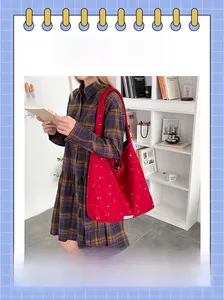 Detail of red wool tote bag with star patterns on a shelf with books