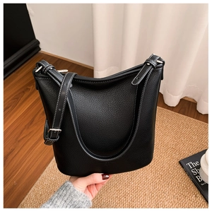 Detail der schwarzen Beuteltasche mit Lychee-Maserung und weißen Kontrastnähten