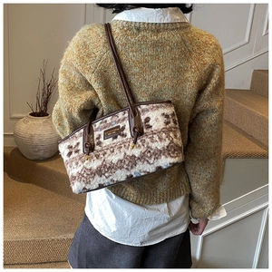 Detailed back view of a large plush tote bag with leather straps on a female model