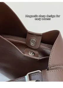 Detail of magnetic snap closure and inner zipper on a dark brown leather tote bag