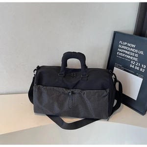 Detail of large travel bag with water-resistant fabric and padded handles in black plaid