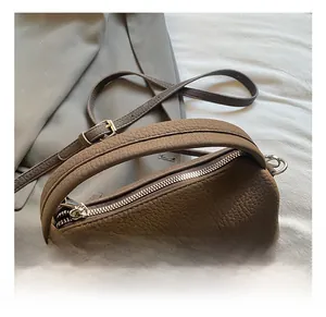 Detailed macro of dark brown lychee leather texture and silver zipper on Boston bag