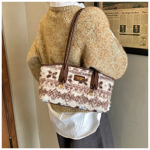 Detail showing plush cream fabric with vintage brown floral patterns and leather strap