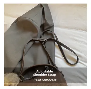 Close-up of adjustable strap and litchi texture on brown crossbody pillow bag