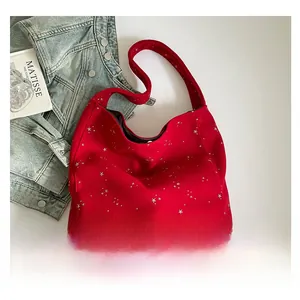 Detailed top view of a large red tote bag with silver star patterns on fabric texture