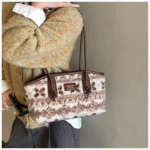 Detail of vintage wool tote bag featuring brown houndstooth pattern and leather handles
