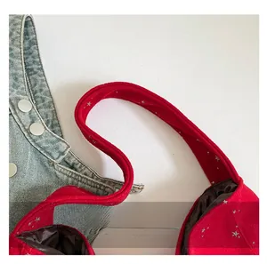 Detail of red suede tote bag with silver star embroidery and sturdy handles