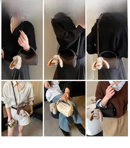Three minimalist textured leather cylinder bags in brown, cream, and black with bunny charms