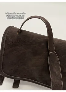 Detailed close-up of adjustable strap and stitching on brown vintage crossbody bag