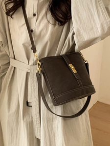 Retro matte bucket bag in charcoal grey with golden metal lock shown on a model