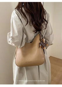 Detail of camel leather tote bag with a small brown horse charm and brand logo