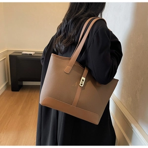 Litchi pattern leather tote bag shown on shoulder with elegant gold buckle detail