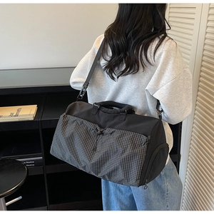 Side view of large capacity travel duffel bag with shoulder strap in lifestyle setting