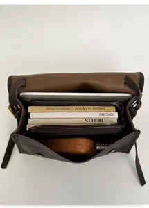 Internal view of brown leather tote showing triple compartment space and magnetic clasp