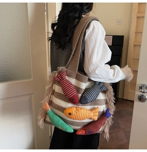 Detail of knit tote bag with 3D colorful fish charms and stylish side fringe accents