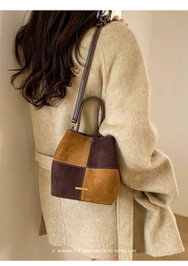 Detail of color-block suede bucket bag showing caramel and brown patchwork texture