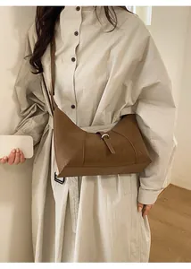 Detail of retro brown PU leather half-moon bag featuring a silver buckle and adjustable strap