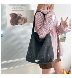 Detailed view of black tote bag with white star pattern and stylish textile label
