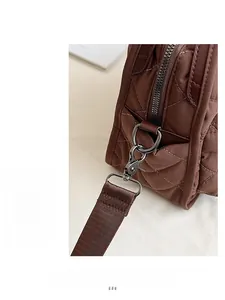 Macro view of brown quilted backpack featuring gunmetal hardware and premium nylon stitching