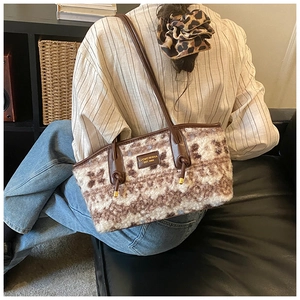 Detailed view of plush faux fur tote bag with brown mottled texture and leather handles