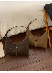Close-up of minimalist suede dumpling bags in dark brown and light coffee colors