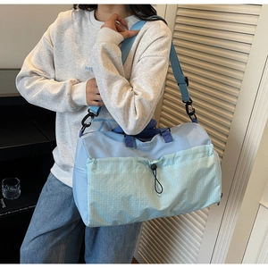 Detail of waterproof nylon travel bag featuring a drawstring front pocket and adjustable strap