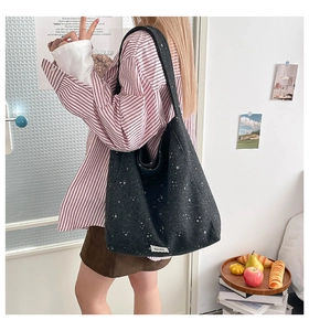Detail of dark grey tote bag featuring star patterns and decorative fabric label