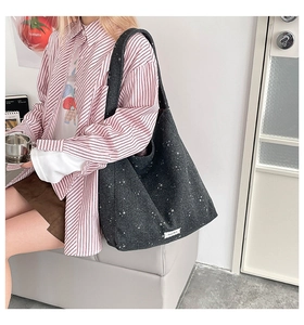 Detail view of dark grey tote bag with white star pattern and soft wool-like texture