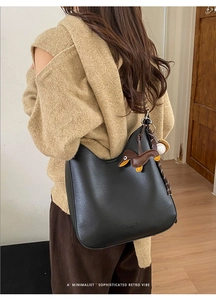 Chic black crescent hobo bag with cute dog charm styled for a vintage retro look