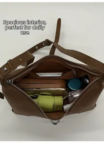 Internal view of brown leather bag showing large capacity with zipper pocket and daily items