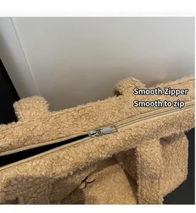 Detail view of smooth metal zipper closure on a khaki plush teddy fleece tote bag