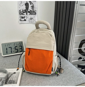 Détail du sac à dos multifonction avec poche orange quadrillée et cordon de serrage