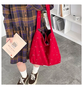 Detail of red canvas tote bag with star patterns and deep brown satin lining inside