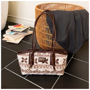 Detail of wool-like tote bag showing geometric patterns and premium leather strap finish