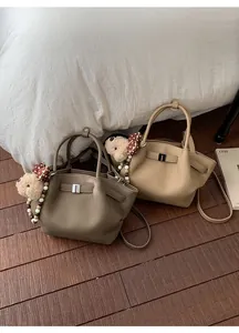 Close-up of litchi grain bucket bags with cute bear charm and polka dot bow detail