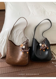 Close-up of retro matte leather bags with cute dachshund charms on a wooden floor