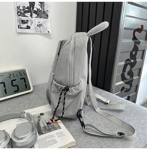 Vue détaillée du sac à dos en nylon gris avec décor d'oreilles de lapin et sangles