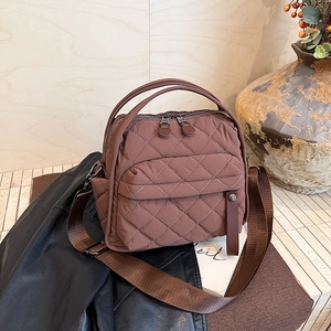Detail of coffee brown quilted nylon shoulder bag with luxury textured stitching
