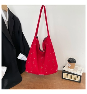 Detailed close-up of large red star pattern canvas tote bag with wide shoulder strap