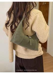 Detail of olive green suede hobo bag with metal buckle and retro minimalist vibe