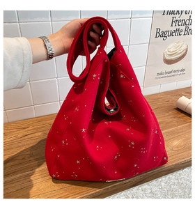 Detail of red felt tote bag with silver star patterns in a cozy home lifestyle setting